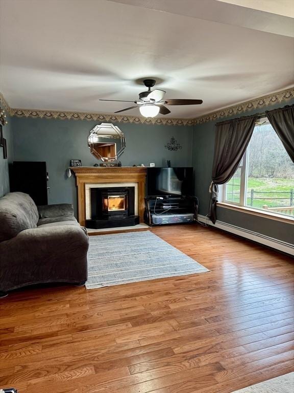 16 E Rd, Adams, MA 01220 - living room with a baseboard radiator, hardwood / wood-style flooring, ceiling fan, and a lit fireplace