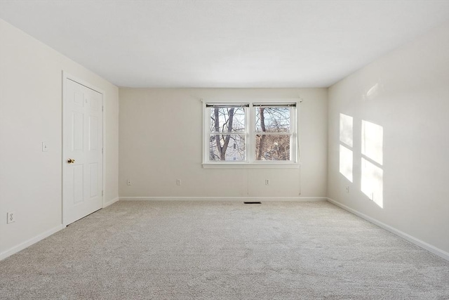 spare room featuring light colored carpet