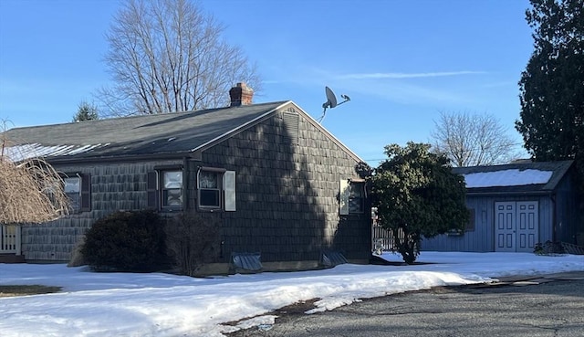 snow covered property with a chimney