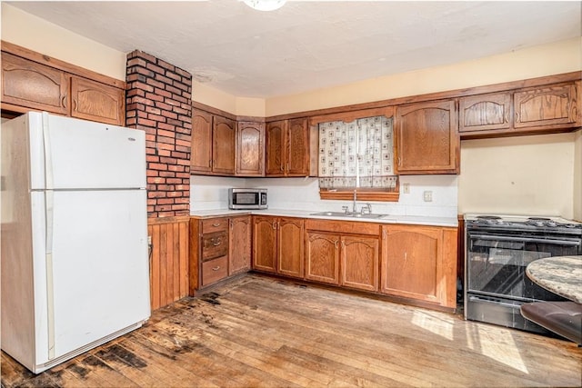15 Green St, Gardner, MA 01440 - kitchen featuring freestanding refrigerator, stove, stainless steel microwave, light wood finished floors, and brown cabinetry