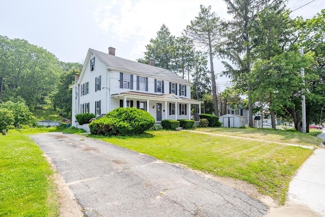 15 Green St, Gardner, MA 01440 - colonial-style house featuring a chimney, a shed, covered porch, and a front lawn