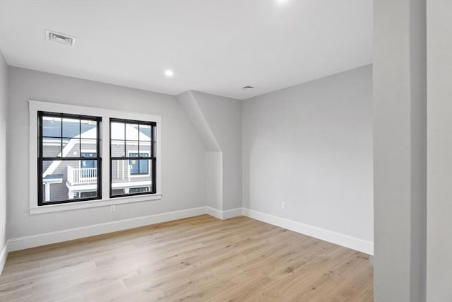 additional living space with light hardwood / wood-style flooring