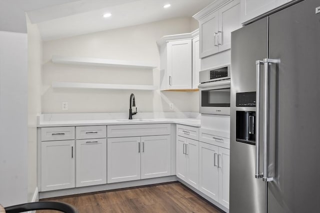 kitchen with stainless steel appliances, white cabinetry, sink, and dark hardwood / wood-style flooring