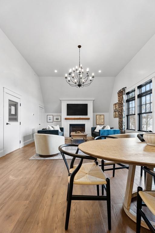 dining space featuring lofted ceiling, light hardwood / wood-style floors, and a chandelier