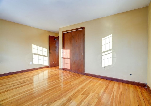 spare room with light wood-type flooring and baseboards