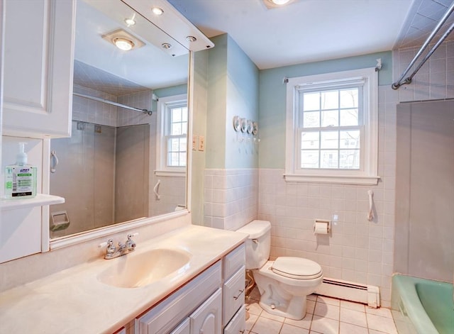 full bath with a baseboard radiator, toilet, vanity, tile walls, and tile patterned floors