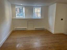 520 Shawmut Ave Unit 1, Boston, MA 02118 - unfurnished room featuring baseboards, a baseboard radiator, and wood finished floors
