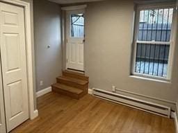 520 Shawmut Ave Unit 1, Boston, MA 02118 - doorway to outside featuring a baseboard heating unit, wood finished floors, and baseboards