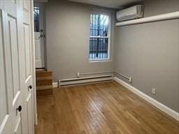 520 Shawmut Ave Unit 1, Boston, MA 02118 - unfurnished room with a wall unit AC, wood finished floors, baseboards, and baseboard heating