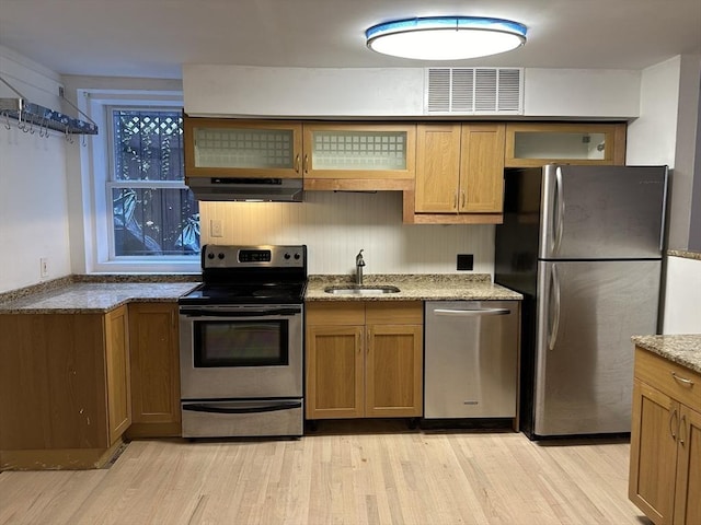 520 Shawmut Ave Unit 1, Boston, MA 02118 - kitchen with appliances with stainless steel finishes, under cabinet range hood, a sink, light wood-style floors, and light stone counters