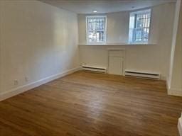 520 Shawmut Ave Unit 1, Boston, MA 02118 - below grade area with a baseboard radiator, baseboards, and wood finished floors