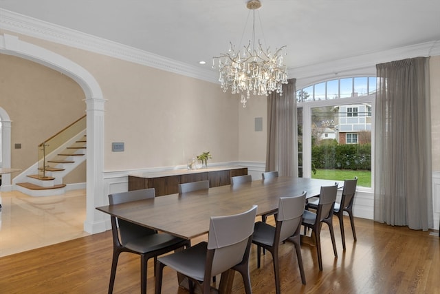 dining area featuring ornamental molding, ornate columns, and wood-type flooring