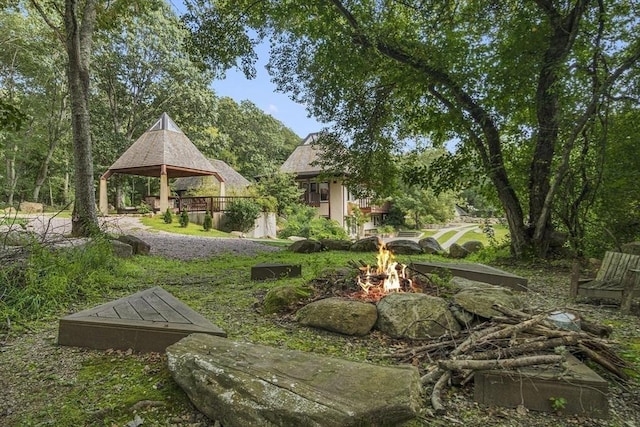 view of community with an outdoor fire pit and a gazebo