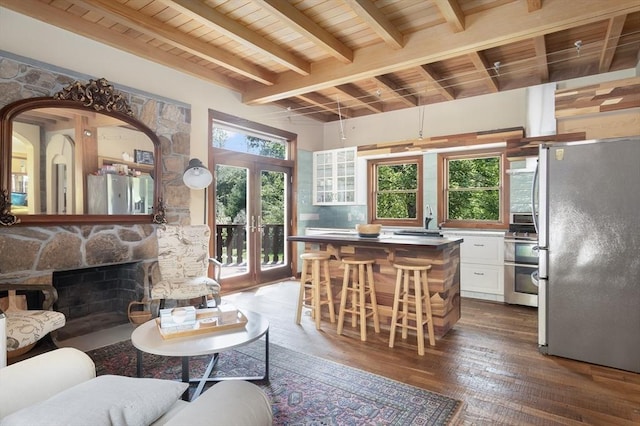 living room with wood ceiling, beam ceiling, plenty of natural light, and wood-type flooring