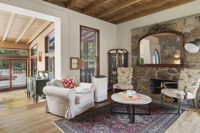 sitting room featuring a fireplace, light hardwood / wood-style floors, beam ceiling, and wood ceiling