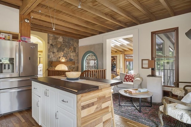 kitchen featuring white cabinets, dark hardwood / wood-style flooring, stainless steel fridge with ice dispenser, wooden ceiling, and beam ceiling