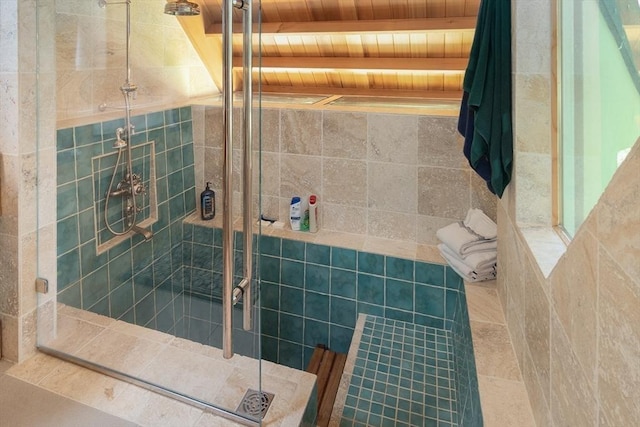 bathroom featuring tiled shower, beamed ceiling, and wood ceiling