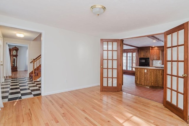 spare room featuring light hardwood / wood-style flooring and french doors