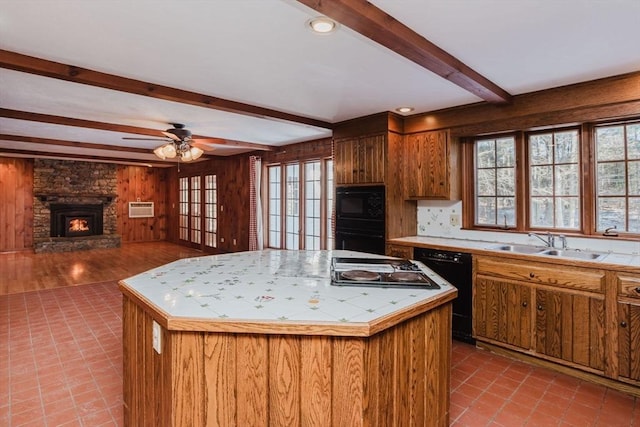 kitchen featuring a healthy amount of sunlight, a center island, sink, and black appliances