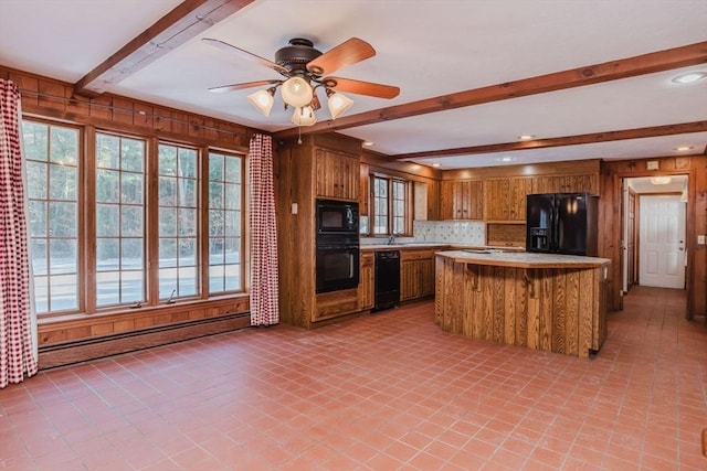 kitchen with wood walls, beamed ceiling, a baseboard radiator, ceiling fan, and black appliances