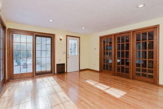 doorway featuring radiator heating unit, light wood-type flooring, and french doors