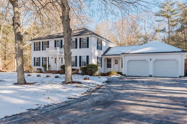 colonial inspired home featuring a garage and a balcony