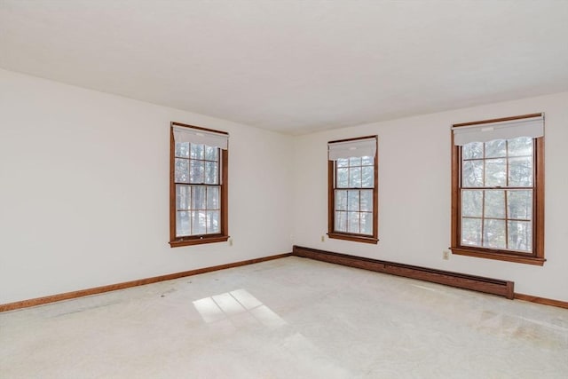 empty room with light carpet and a baseboard heating unit