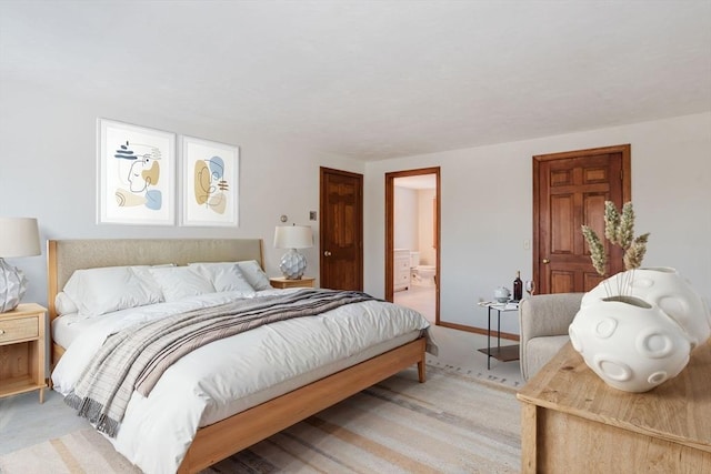 bedroom with ensuite bath and light colored carpet