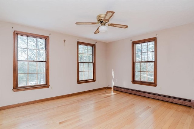 empty room with ceiling fan, light wood-type flooring, and a baseboard heating unit