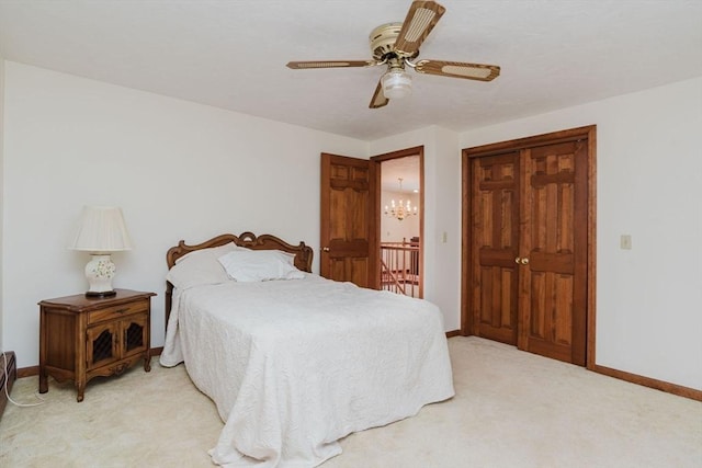 carpeted bedroom featuring ceiling fan with notable chandelier and a closet