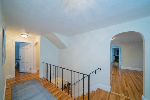 642 Centre St, Newton, MA 02458 - hallway with wood finished floors, arched walkways, baseboards, and an upstairs landing