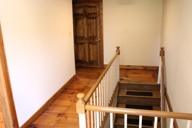 staircase featuring baseboards and wood finished floors