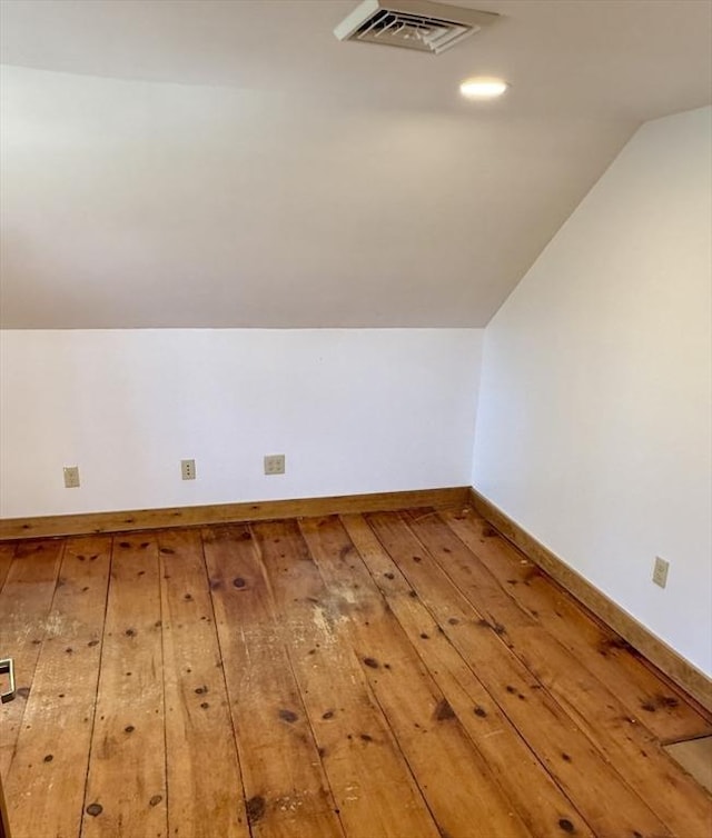 bonus room with baseboards, vaulted ceiling, hardwood / wood-style floors, and visible vents