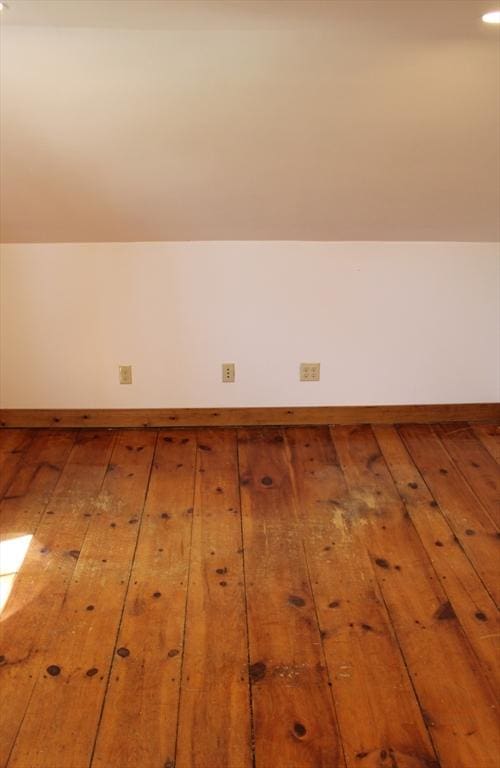 bonus room featuring baseboards and hardwood / wood-style flooring