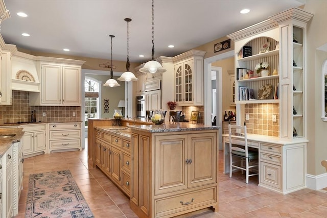 kitchen with a kitchen island, pendant lighting, cream cabinetry, and open shelves