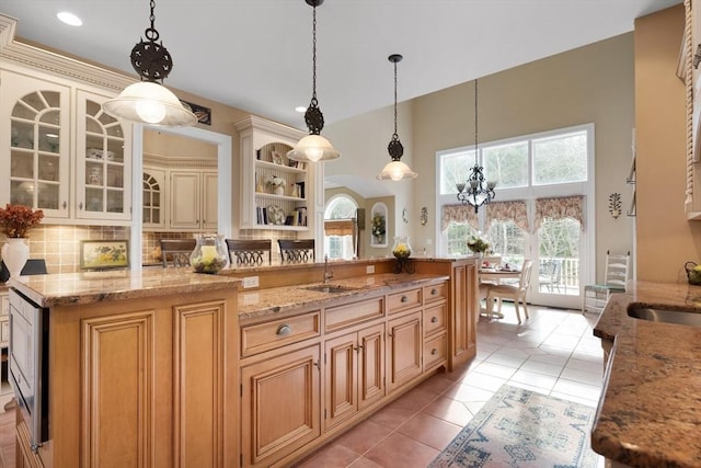 kitchen featuring hanging light fixtures, light stone counters, open shelves, and glass insert cabinets