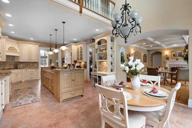 dining room with arched walkways, a fireplace, recessed lighting, coffered ceiling, and beamed ceiling