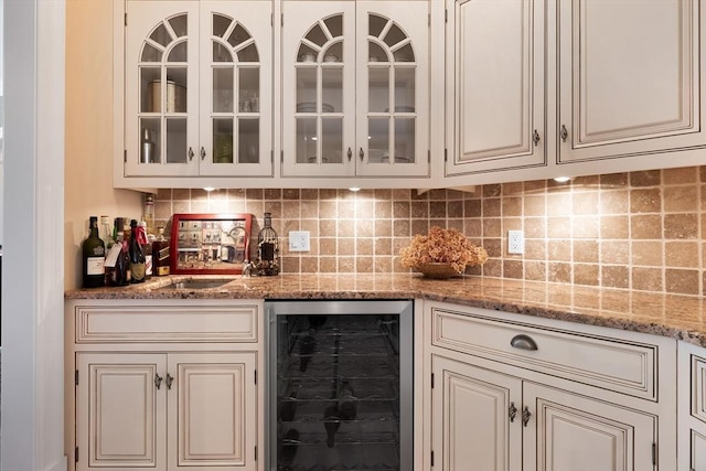 bar featuring a sink, a bar, wine cooler, and backsplash