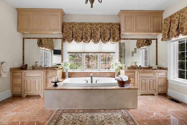 bathroom with a sink, two vanities, a garden tub, and visible vents