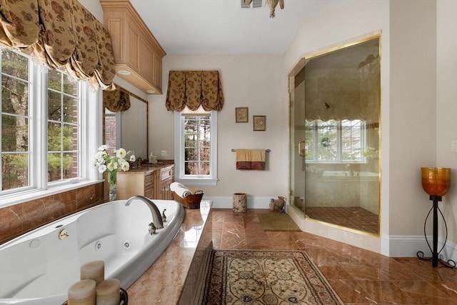 bathroom featuring a healthy amount of sunlight, a shower stall, a whirlpool tub, and vanity