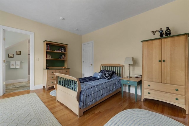 bedroom featuring light wood-style floors and baseboards