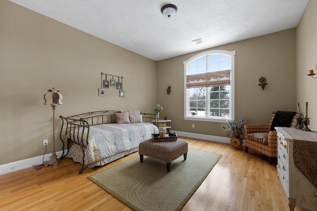 bedroom with light wood-type flooring, baseboards, and visible vents