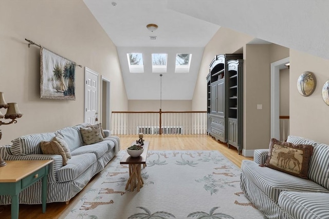 living room featuring light wood-style floors, vaulted ceiling with skylight, and visible vents