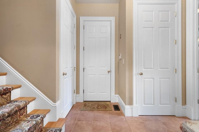 entrance foyer featuring stairs, visible vents, and light tile patterned floors