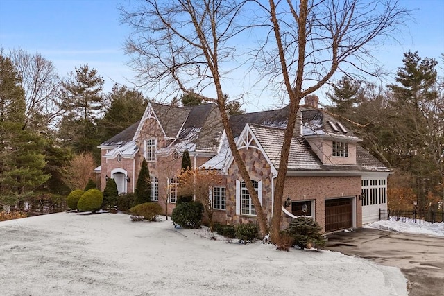 view of front of home with stone siding, brick siding, and driveway