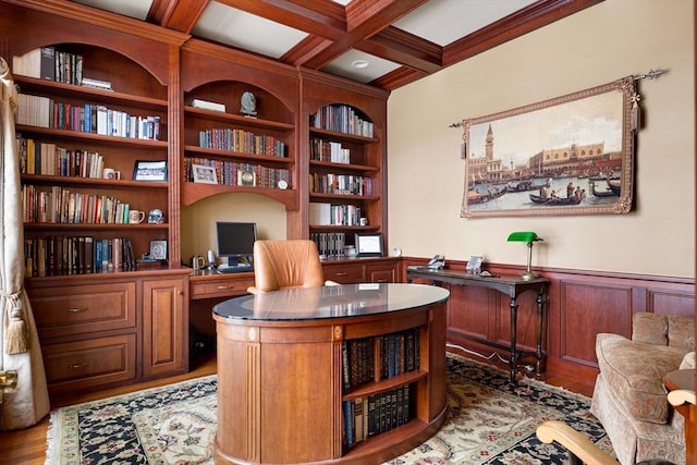 office space with built in shelves, a wainscoted wall, coffered ceiling, wood finished floors, and beam ceiling