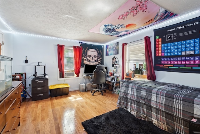 bedroom featuring light wood-type flooring and a textured ceiling