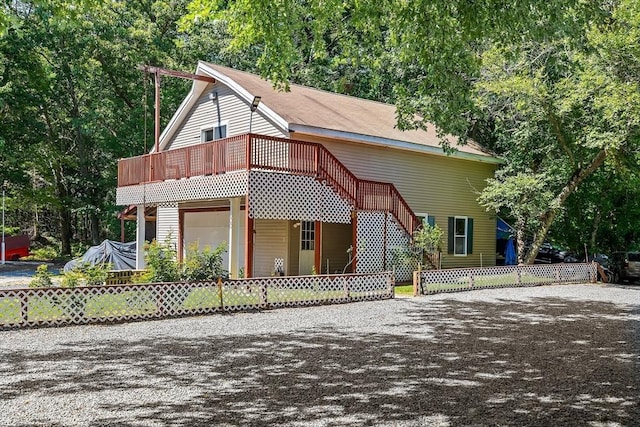 view of front facade with a fenced front yard, stairway, driveway, and an attached garage