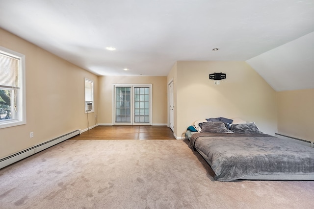 bedroom with a baseboard radiator, hardwood / wood-style flooring, and vaulted ceiling