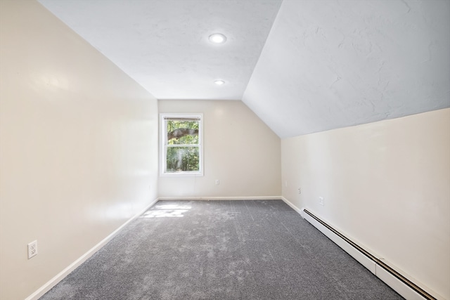 additional living space with a baseboard heating unit, carpet flooring, and vaulted ceiling